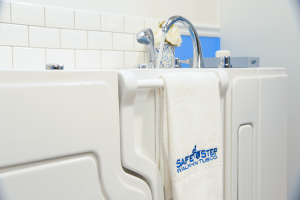 A branded Safe Step Walk-in Tub Co towel hanging from a Safe Step Tub hand grip
